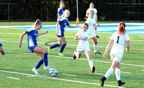 Alyssa Clutter and Courtney Lowe engaged in a soccer game.