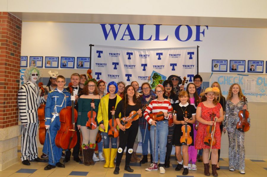 Orchestra students show off their creative costumes and pose with their instruments after a successful concert.