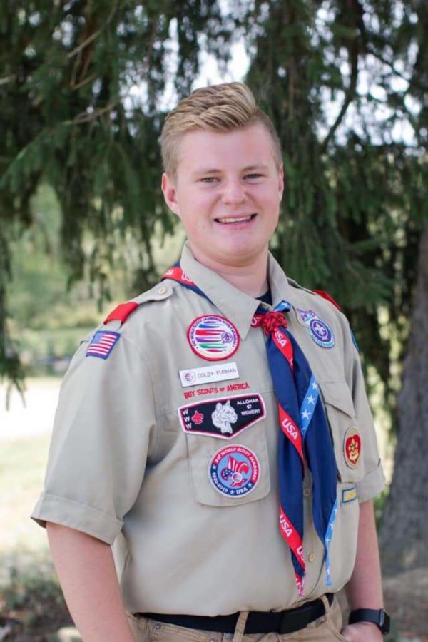 Senior Colby Furman stands proudly in his scouts uniform for a senior picture. His uniform includes patches that he has earned from achievements throughout his years in scouts. 