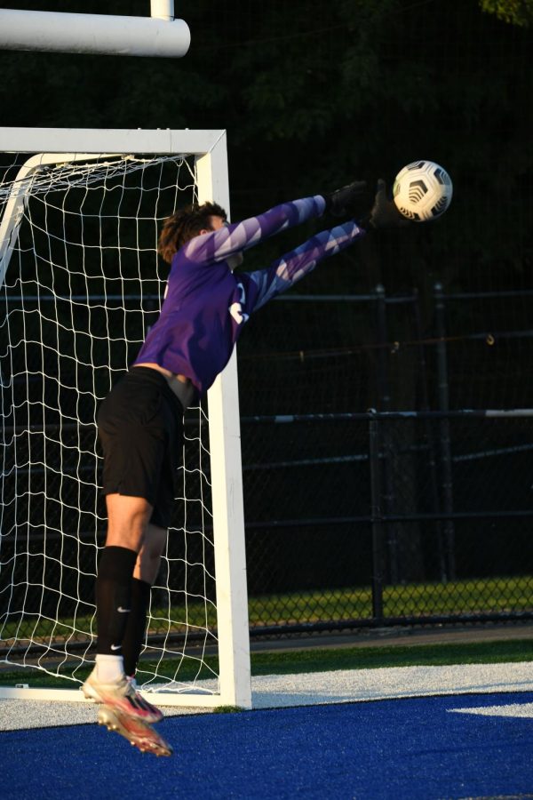 Goalie Connor Bull leaps to defend the net. He blocks the ball and keeps the visitors from scoring! 