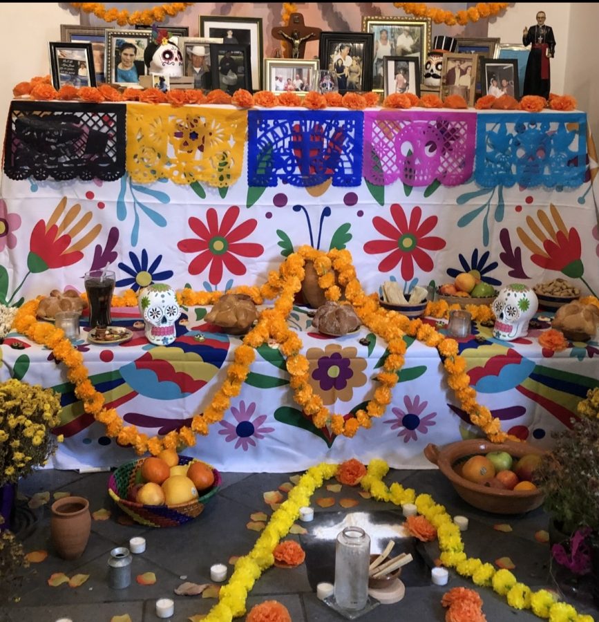 An+ofrenda+is+decorated+with+bright+orange+flowers%2C+loved-ones+favorite+foods%2C+and+other+symbols.+Every+year%2C+this+is+how+part+of+the+local+Hispanic+community+celebrates+El+Dia+de+Los+Muertos.