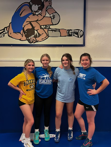 The four members of the girls wrestling team. Junior Nila Bland, Freshman Lily Hoy, Senior Anna Johnson and Junior  Kenzie Phasupong. 
