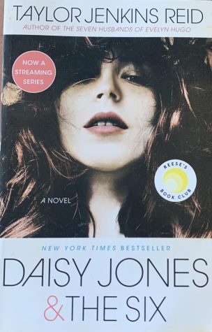 Daisy Jones posed on the original cover of the book “Daisy Jones & The Six” by Taylor Jenkins Reid. The book is a New York Times Bestseller and fans can interact with other lovers of the book through Reese’s Book Club made by the producer of the series, actress Reese Witherspoon.