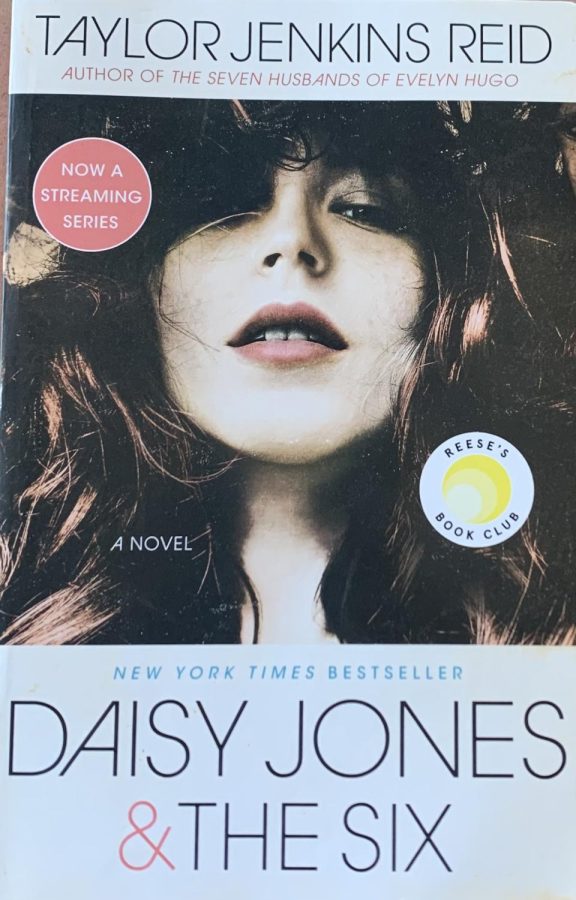 Daisy+Jones+posed+on+the+original+cover+of+the+book+%E2%80%9CDaisy+Jones+%26+The+Six%E2%80%9D+by+Taylor+Jenkins+Reid.+The+book+is+a+New+York+Times+Bestseller+and+fans+can+interact+with+other+lovers+of+the+book+through+Reese%E2%80%99s+Book+Club+made+by+the+producer+of+the+series%2C+actress+Reese+Witherspoon.