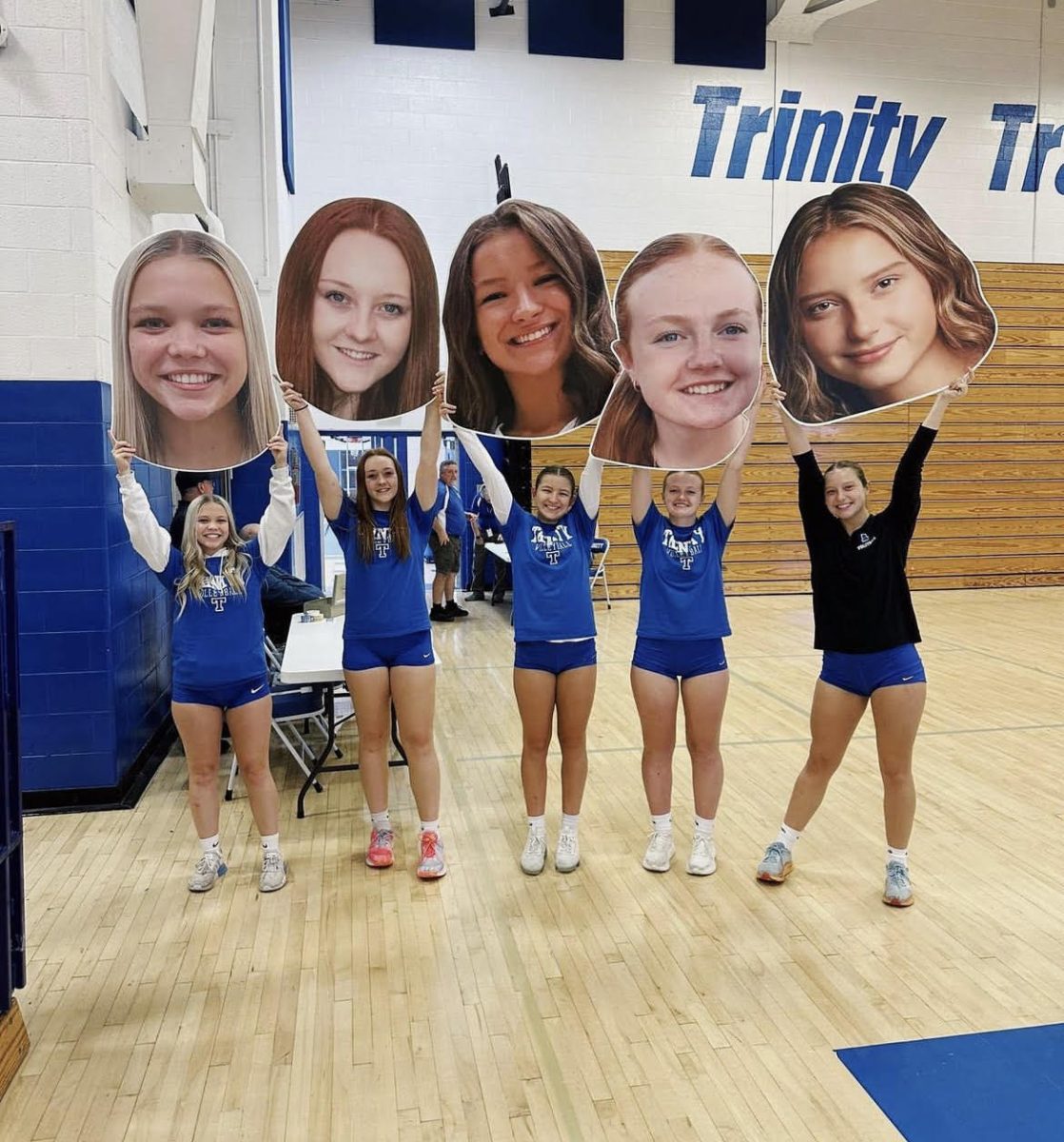 The+senior+girls+on+the+volleyball+team+hold+up+their+%E2%80%9Cfat+heads%E2%80%9D+at+their+game.+Their+senior+night+took+place+on+October+26+with+a+score+of+3-0.+