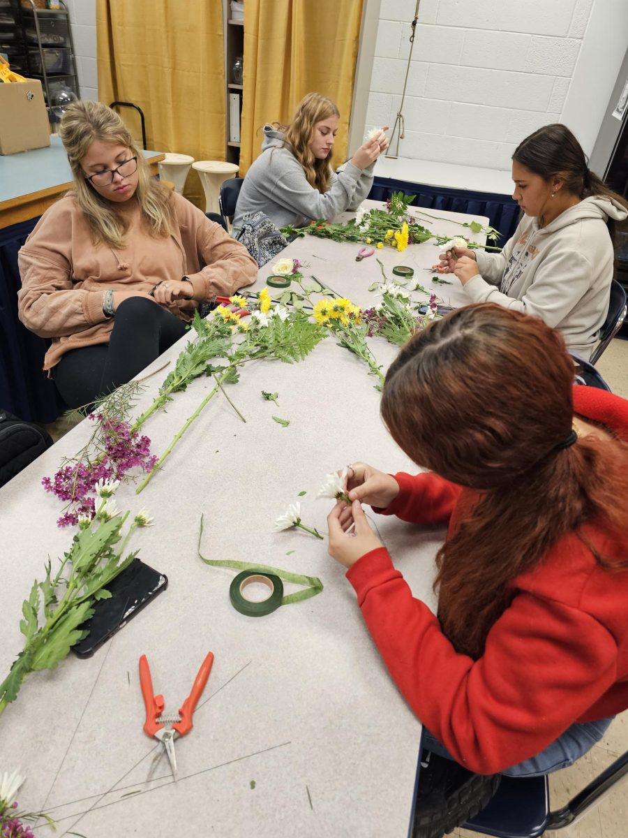 Pictured above are some of the floral design students creating their own floral arrangements with donated flowers to display what they have learned.