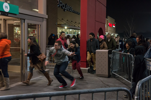 A group of shoppers outside of a shopping center gathers and rushes into the storefronts on Black Friday. Back in the day, Black Friday was all about the hustle and bustle! Getting that deal meant battling the crowd.