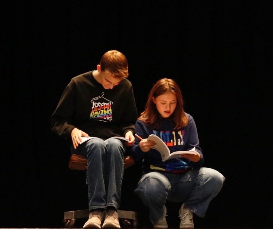 Miller and Drezewski rehearse their lines as Willy Wonka and Charlie for the upcoming musical. The relationship between the two characters changes throughout the movie, changing from a distant admiration to a mentoring relationship. 
