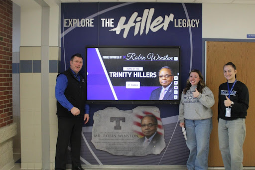 Lucas, Alderson and senior Katherine Drezewski pose with the new touchscreen located in the main foyer. The Trinity students are very appreciative for Winston's generous donation!